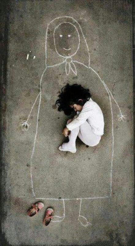 在伊拉克,一个没有妈妈的小女孩,在孤儿院的水泥地面上,画了一个妈妈.